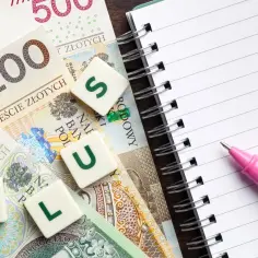 Polskie banknoty, notatnik i różowy długopis. Litery P, L, U, S.