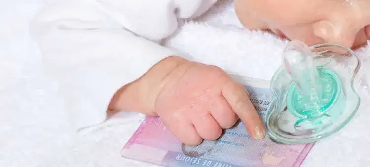rodzic z noworodkiem wypełniający dokumenty